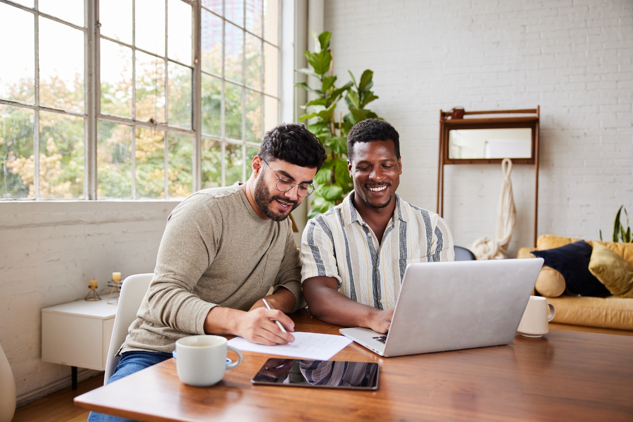 couple sat at a table on a laptop