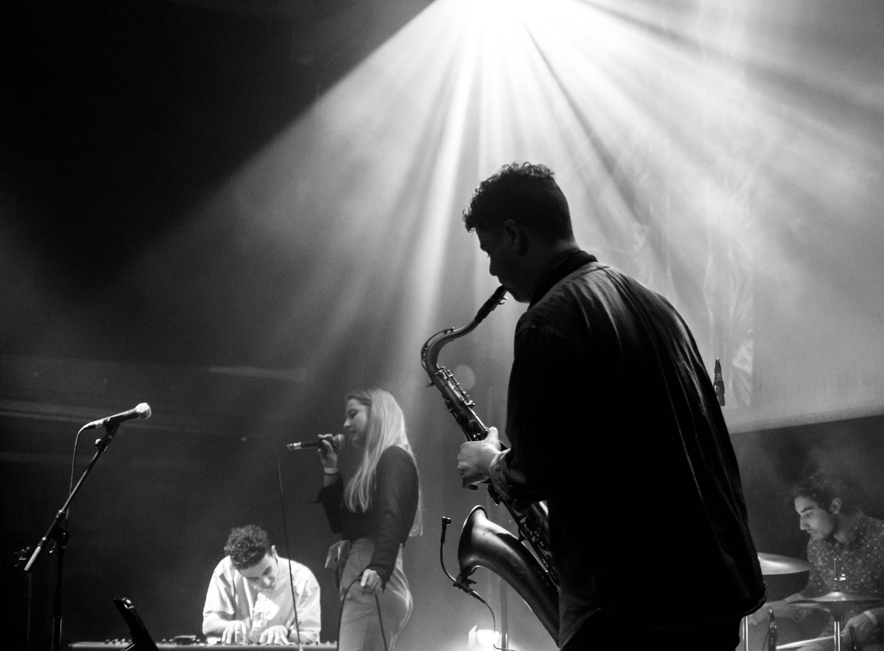 black and white image of a saxophone player with a band 
