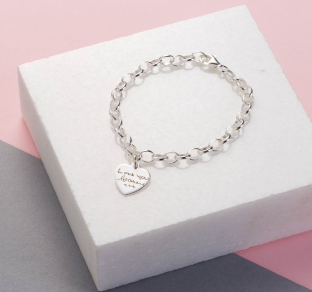 a silver link bracelet with a heart with i love nanny on