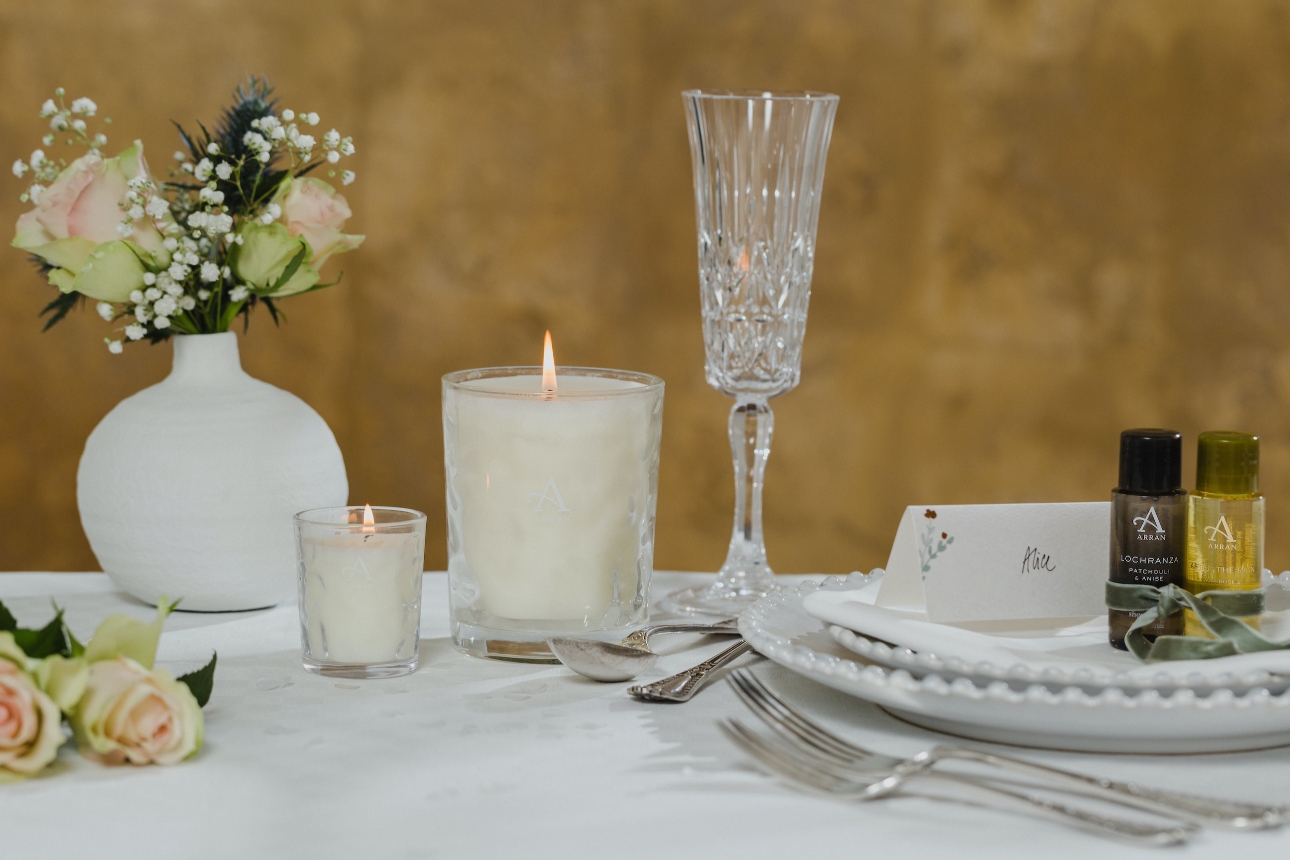 table setting at reception laid out with candles and foliage in the centre