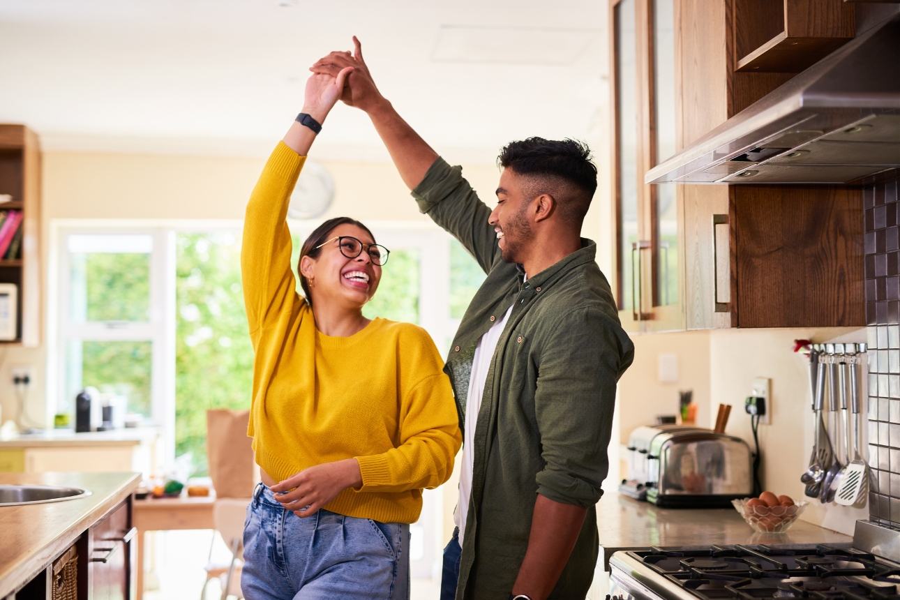 man and woman dancing in their kitchen