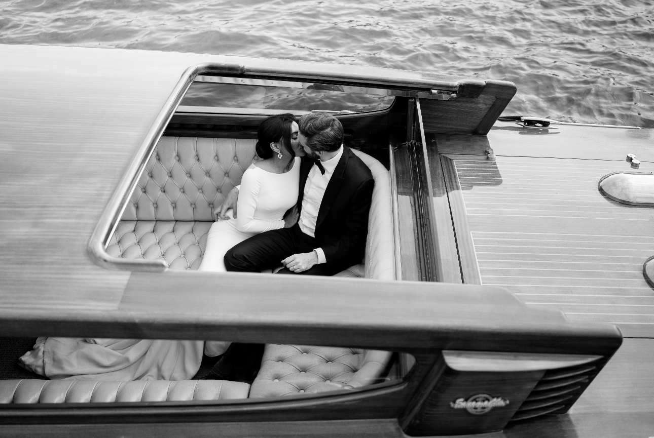 stylish bride and groom kissing on a speed boat