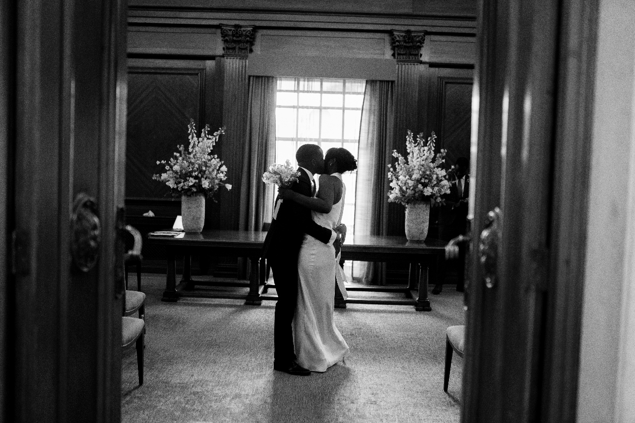 bride and groom kissing in wedding clothes in manor house