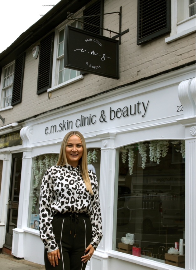 salon manager standing in front of shop with leopard print top on