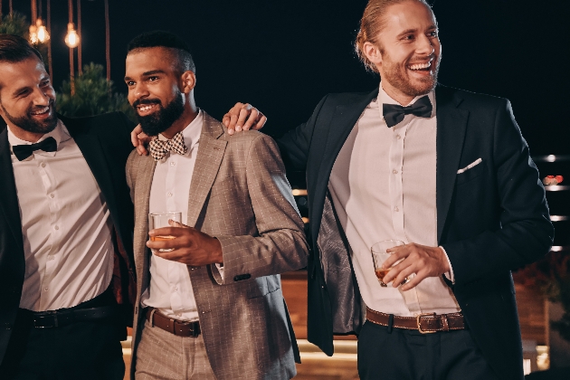Three men wearing suits laughing