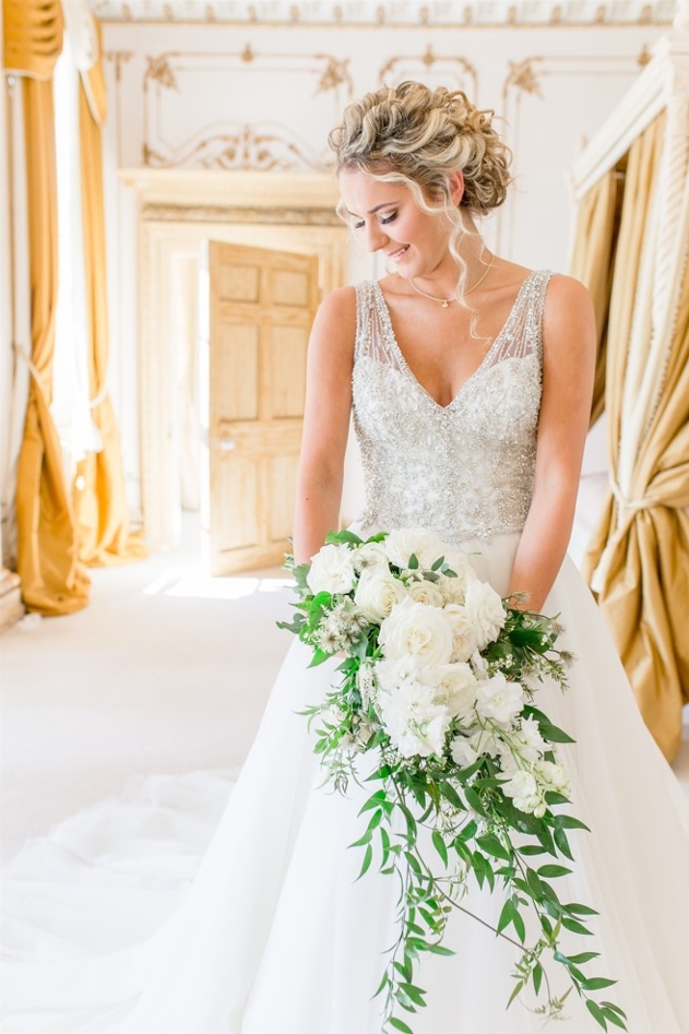 bride holding bouquet in a stately bedroom