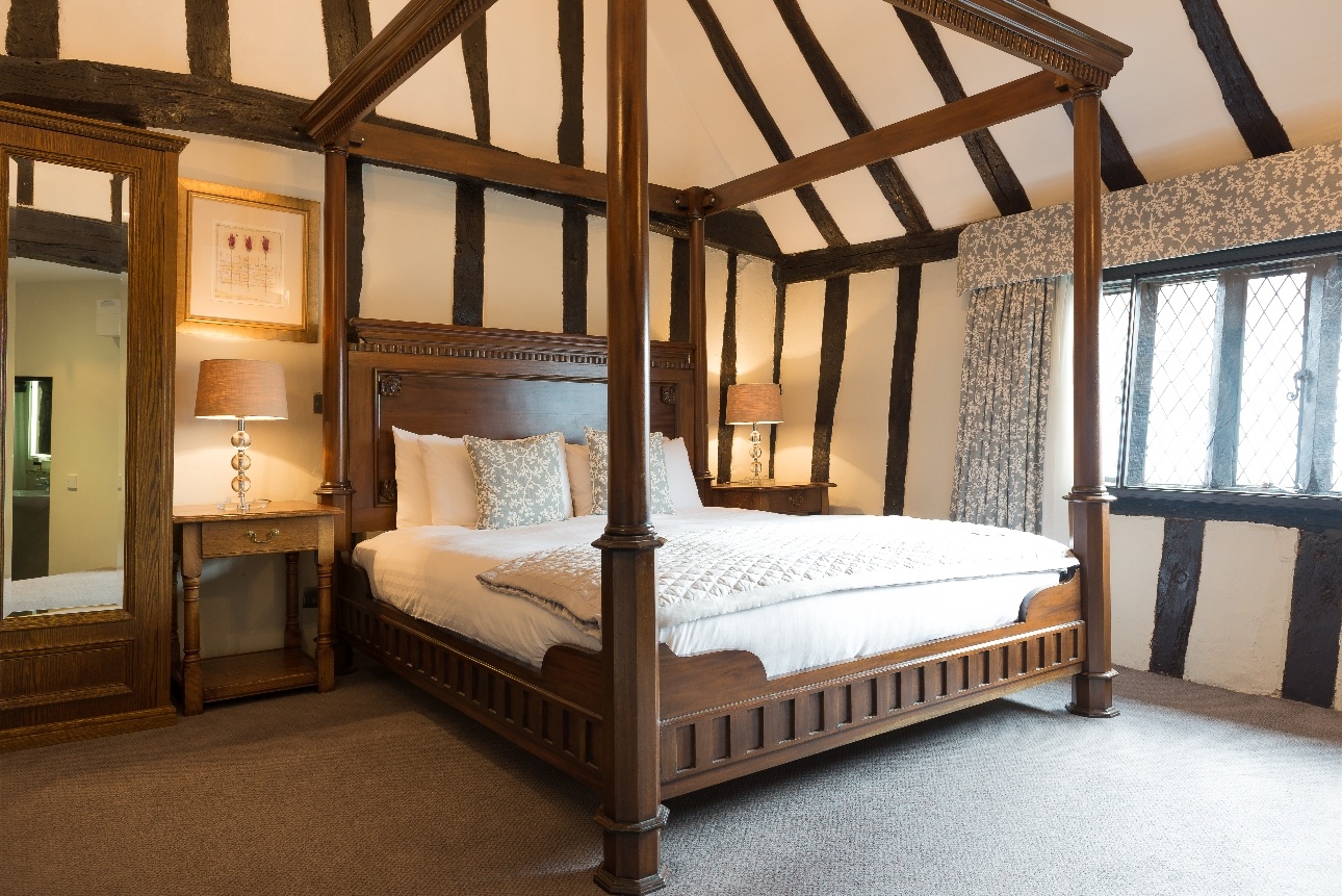 four poster wood bed in beamed room