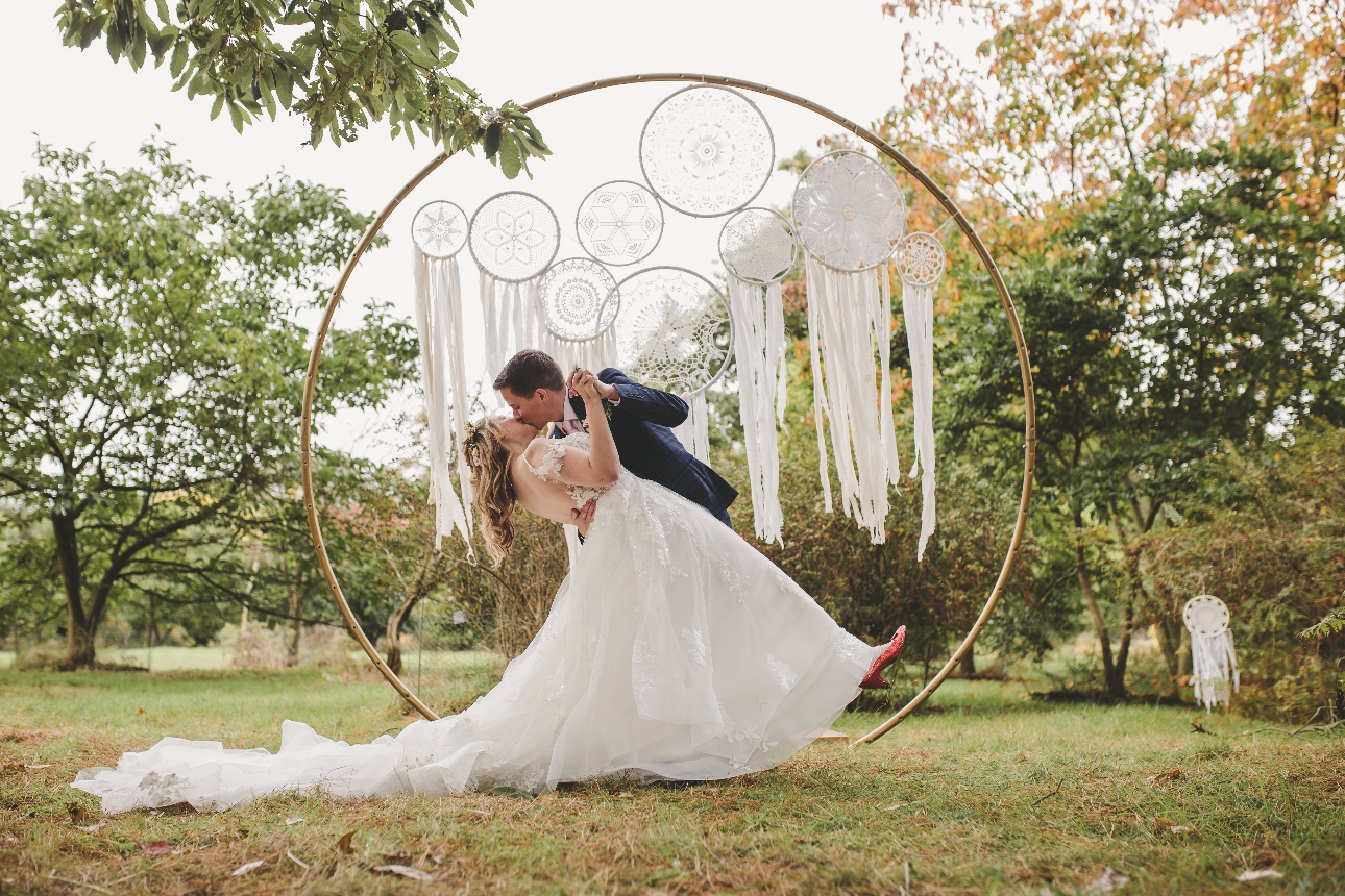 couple kissing in front of macrame moongate 