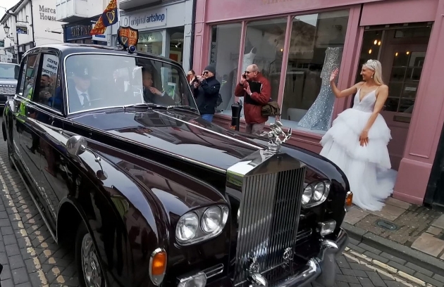 bride waving at royal members inside black rolls royce