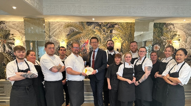 Group of hotel staff members holding an award