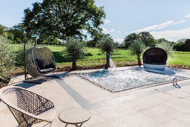 outdoor jacuzzi wicker hanging chairs round it 