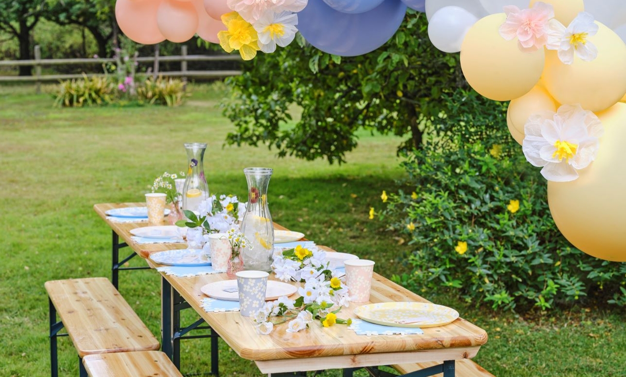 table set up for a spring party out side pastel balloons