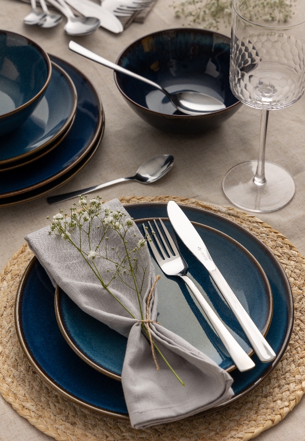 blue crockery with natural linen napkin place setting