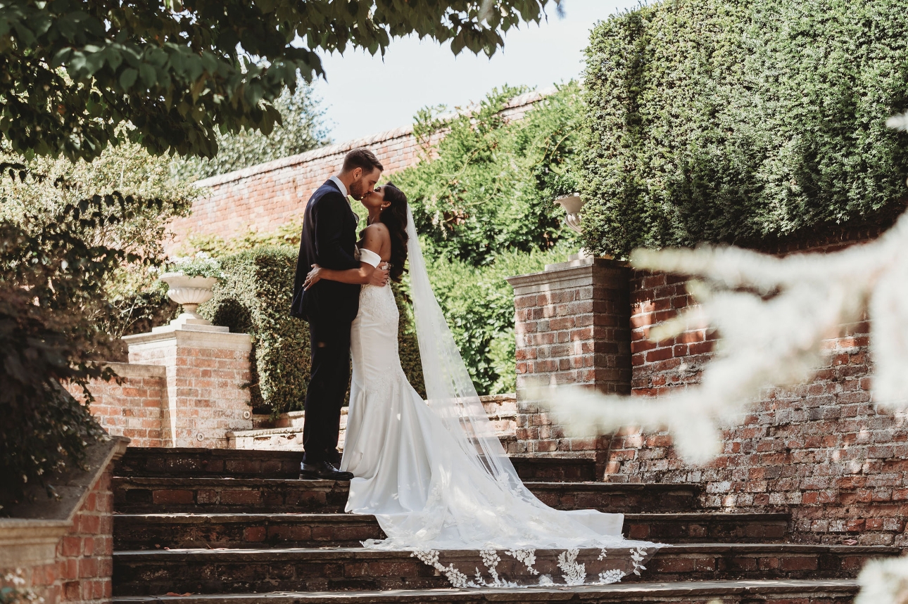 bride and groom kissing on garden steps