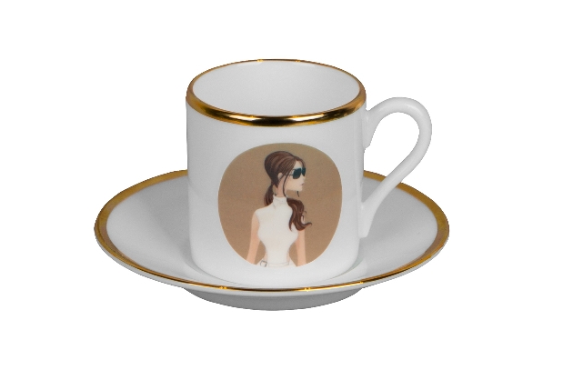 white mug in saucer with gold rim victoria beckham print on it