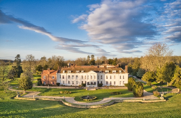 aerial view of white manor house on a sunny day