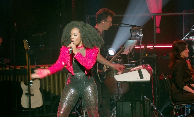 female singer holding microphone wearing pink jacket