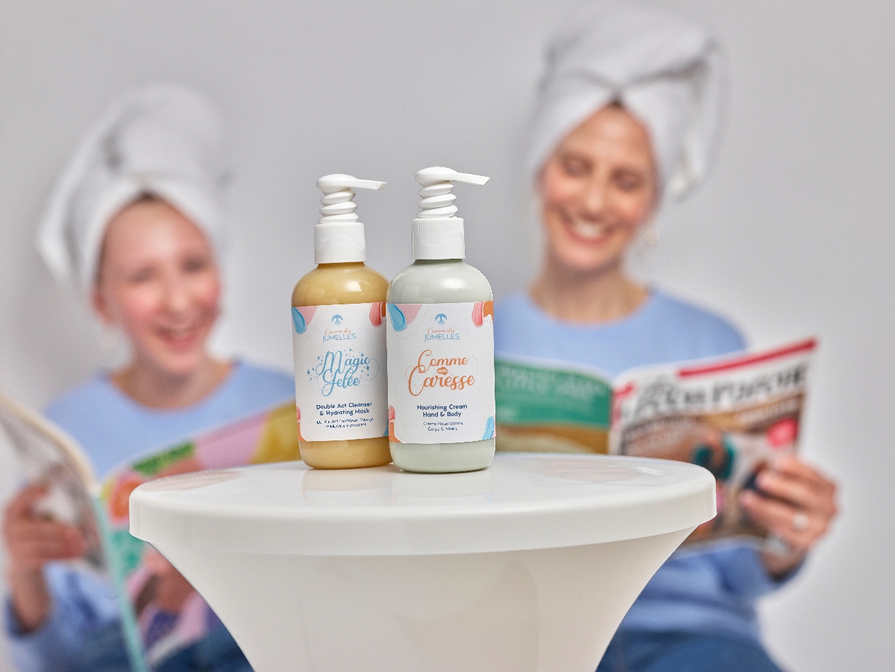 two products on a table with mum and daughter reading magazines in the background