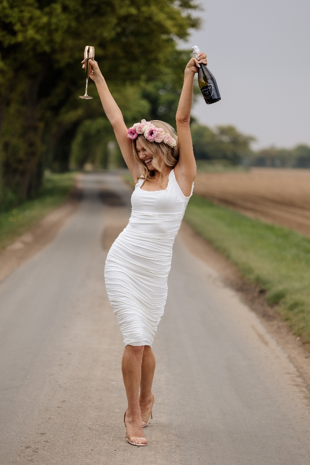 lady jumping for joy holding bottle of champagne