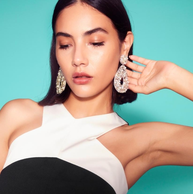 lady with short black hair wearing large gold earrings