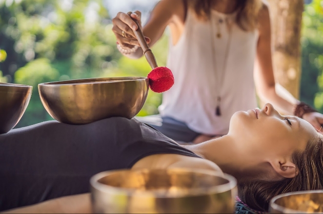 Lady lying down and gong bath taking place 