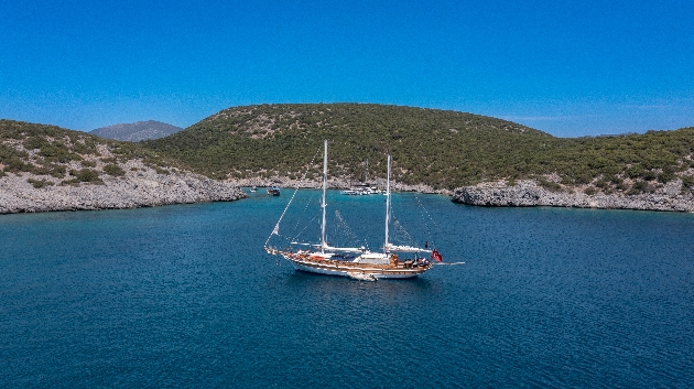 A boat sailing in the sea with mountains in the background