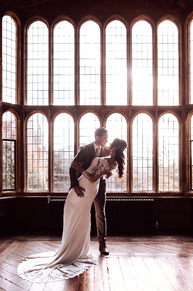 couple dancing in front of grand windows
