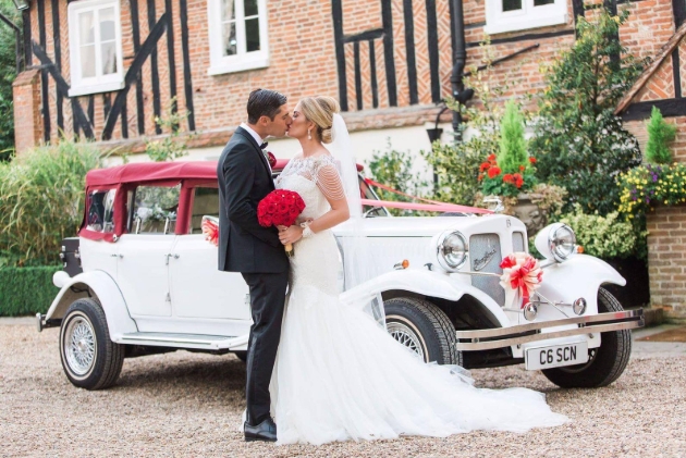 bride and groom in front of beauford wedding car