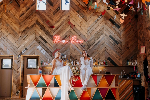 two ladies in wedding attire in a barn