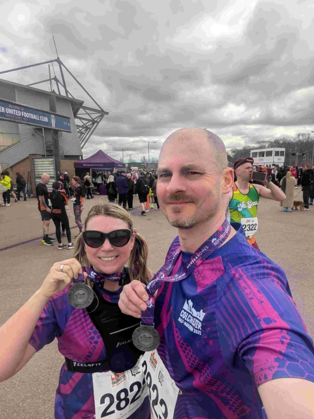 man and lady in sports clothes holding up medals