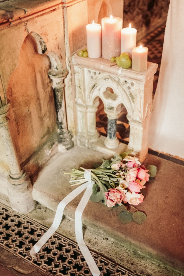 bridal bouquet in front of pillar candles