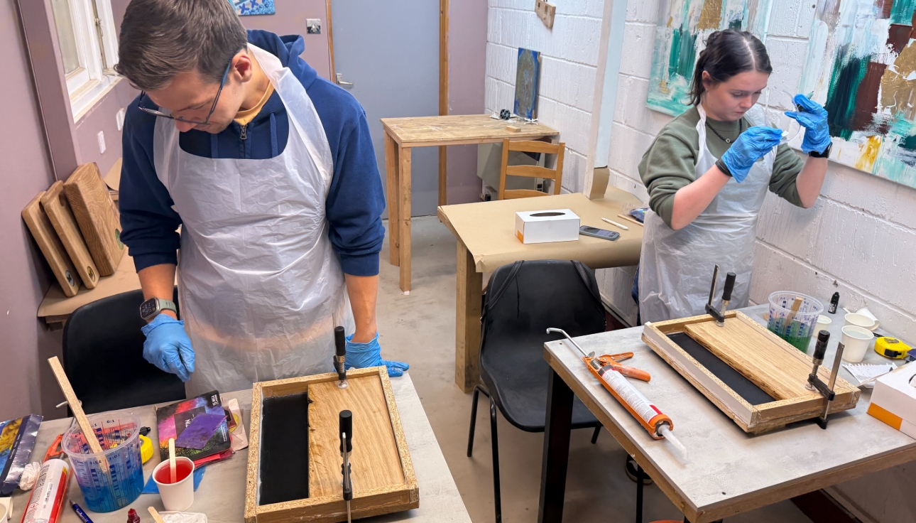 Man and woman creating resin and wood serving board at Blueprint Woodcraft Canvey