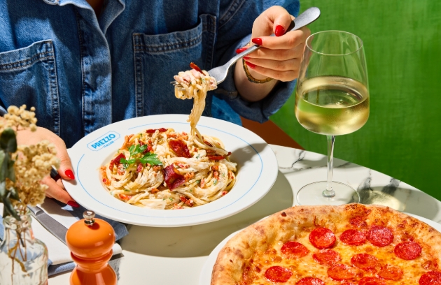 restaurant table with pepperoni pizza and spaghetti dish