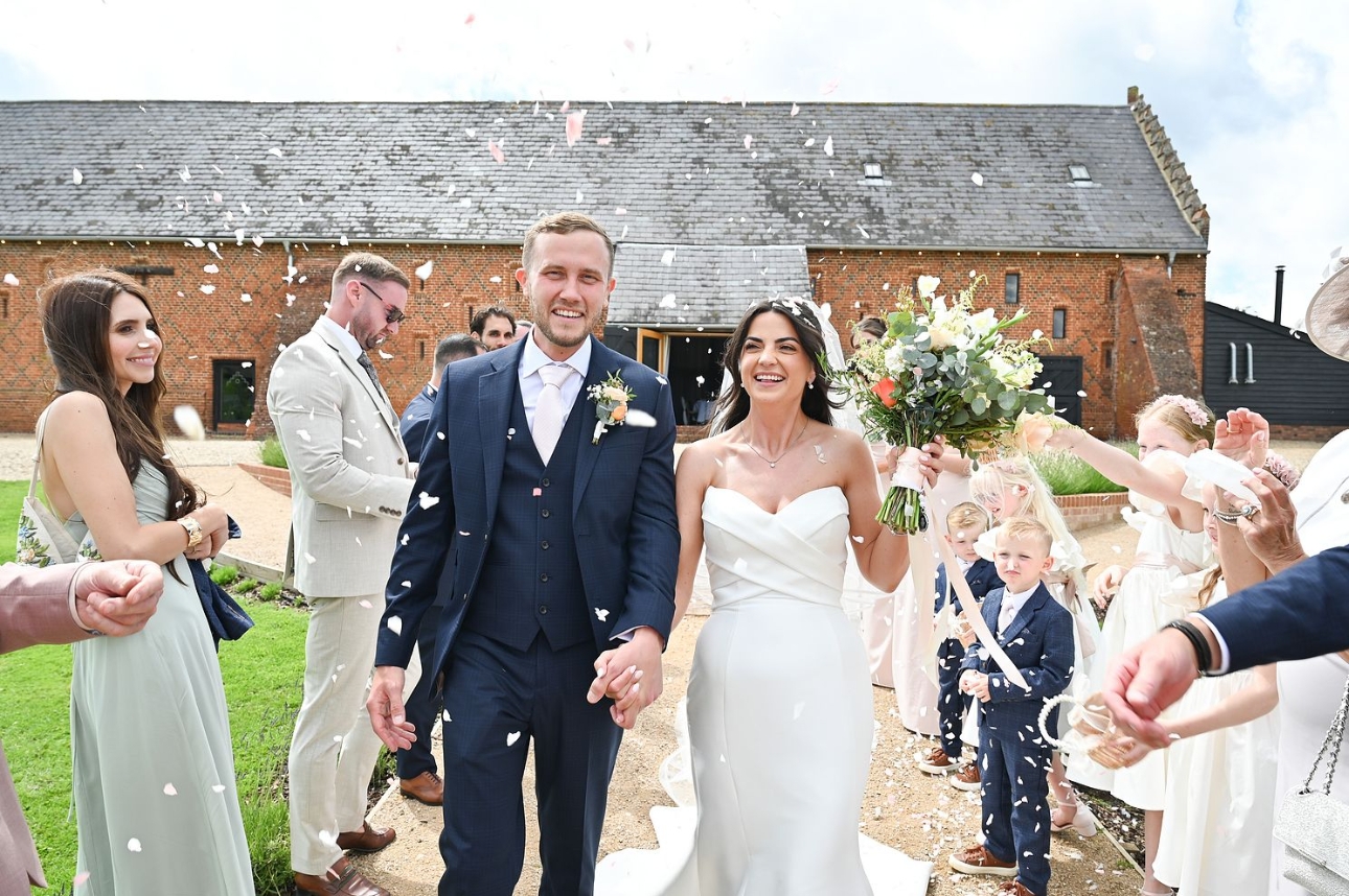 couple on their wedding day leaving ceremony confetti shot